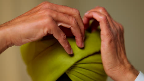 Close-Up-Studio-Shot-Of-Senior-Sikh-Man-With-Beard-Tying-Fabric-For-Turban-Viewed-From-Behind-Shot-In-Real-Time-2